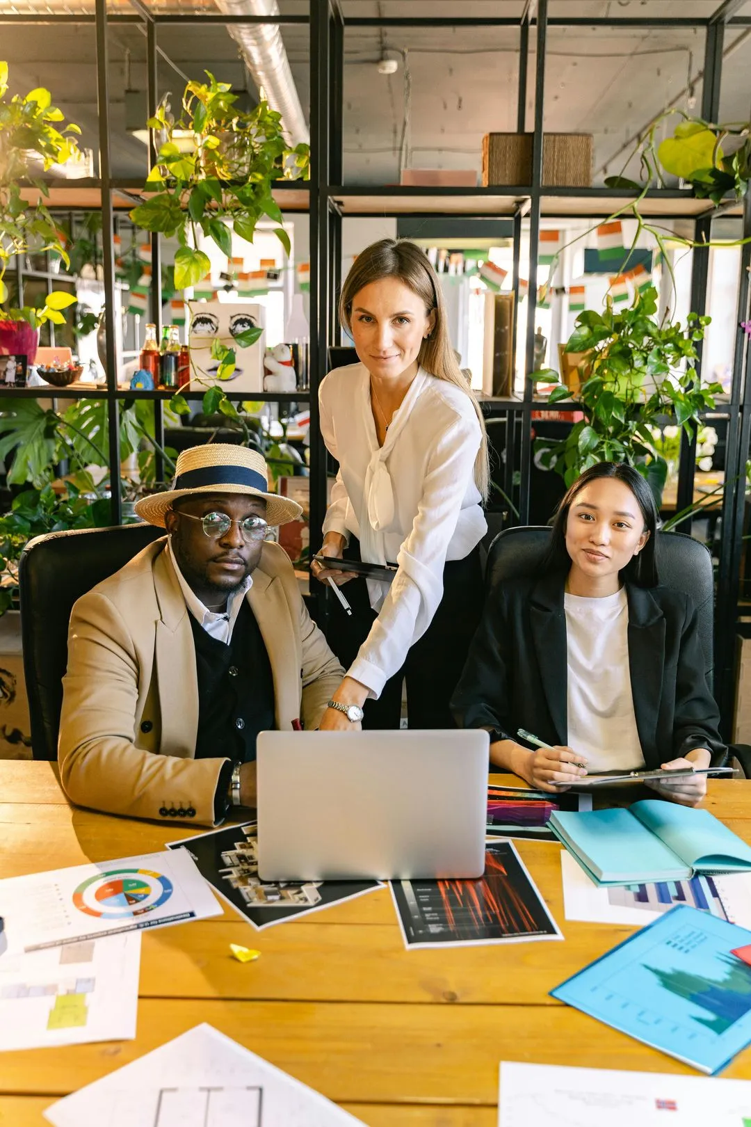 DesignFlow team members collaborating in a plant-filled office space